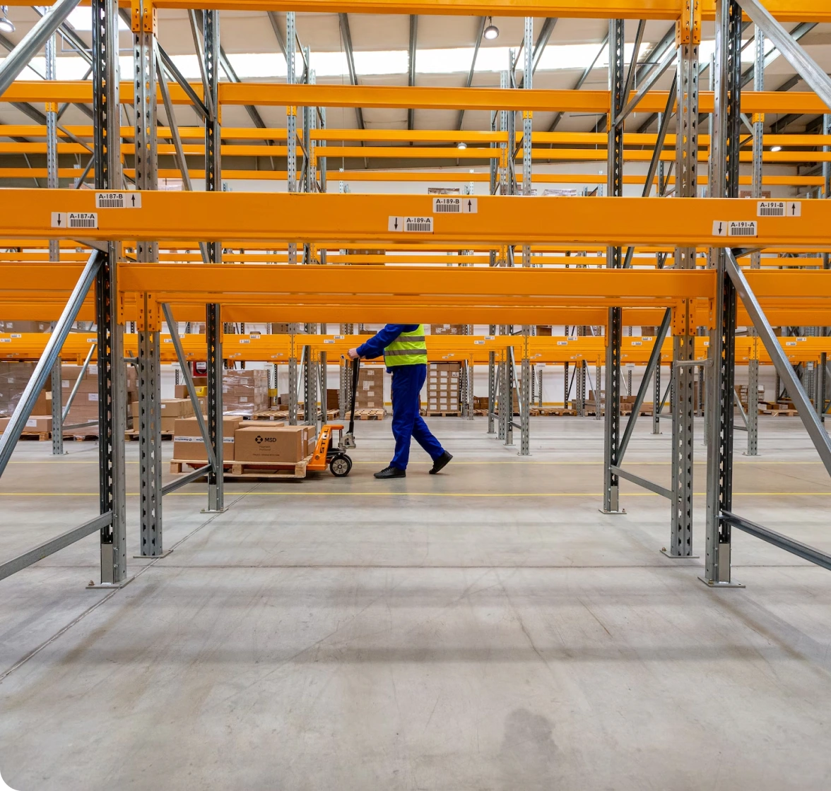 Professional Plastics warehouse employee moving stock with a trolley