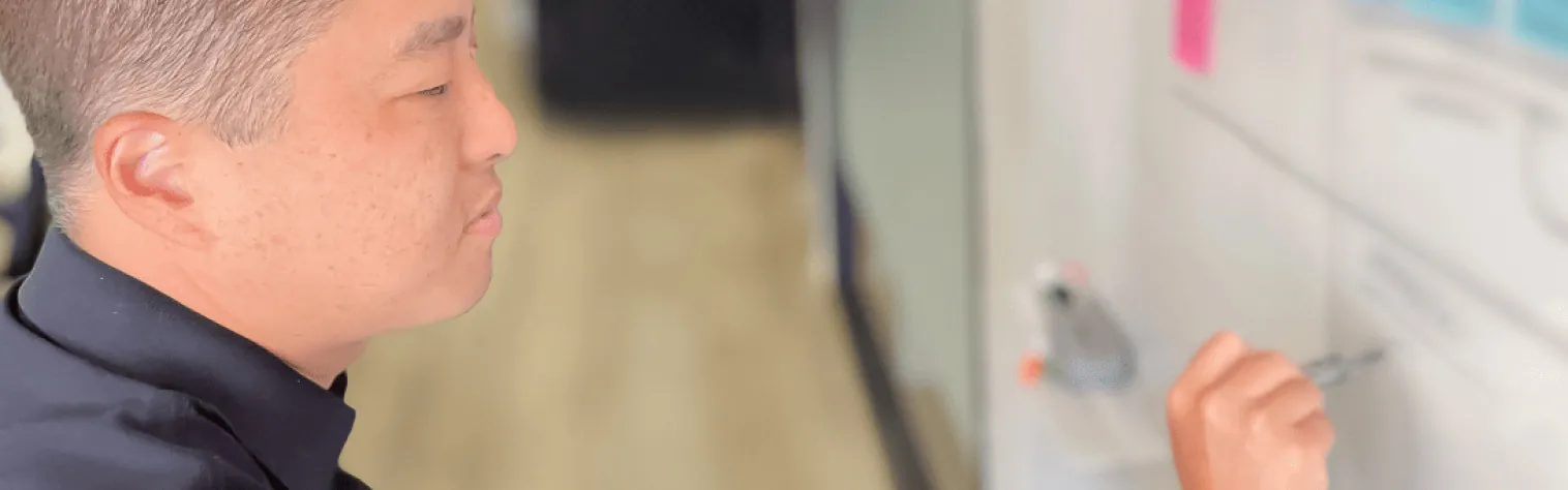 Person writing-on a whiteboard Recruiter mapping out a hiring plan on a whiteboard