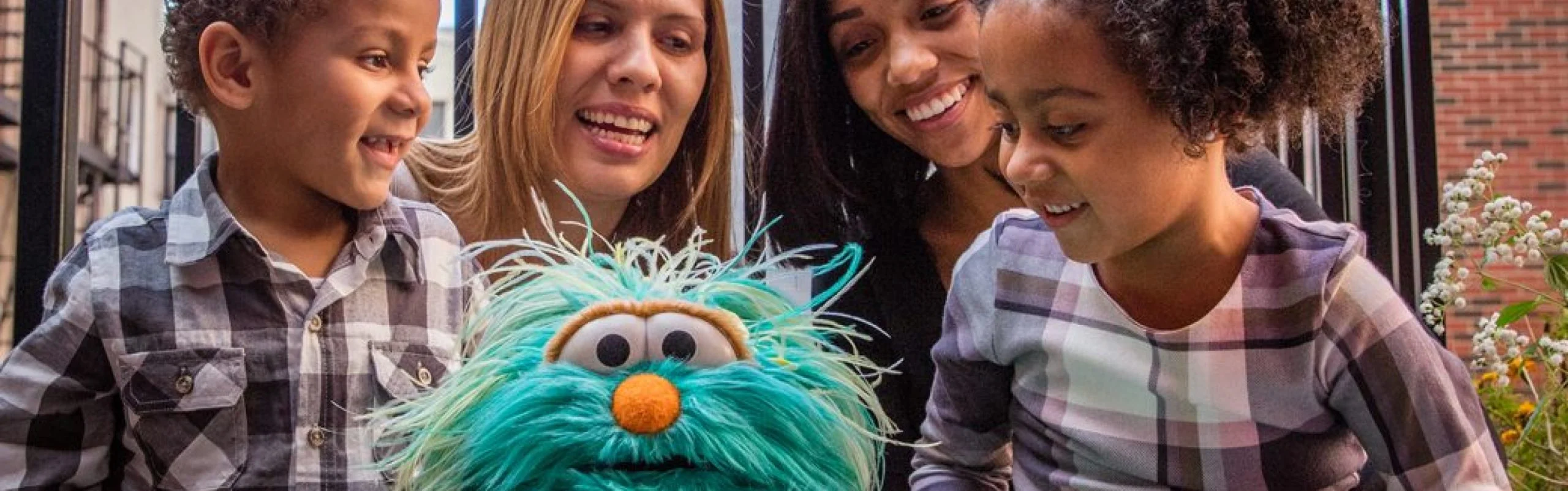 Person writing-on a whiteboard Rosita from Sesame Street with two parents and two children
